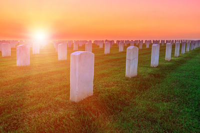 View of cross at cemetery against sky during sunset