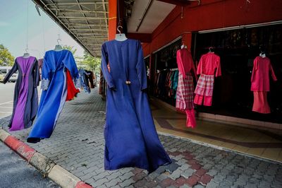 Panoramic view of clothes hanging on footpath