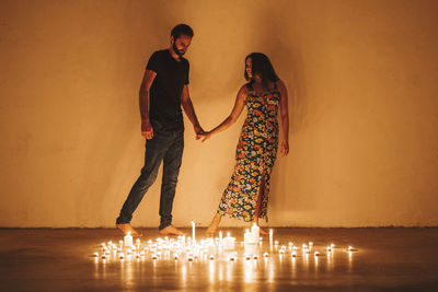 Friends standing against illuminated wall