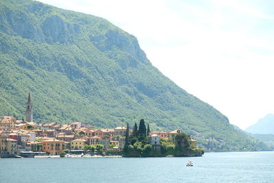 Buildings by sea against mountain