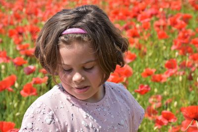 Portrait of young woman standing amidst flowers