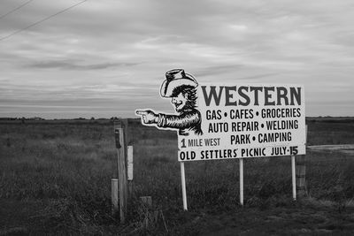 Close-up of road sign on landscape against sky