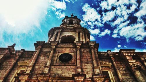 Low angle view of bell tower against cloudy sky