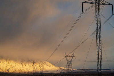 Electricity pylon against sky during sunset