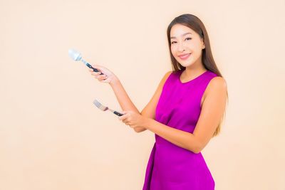 Portrait of a smiling young woman against white background