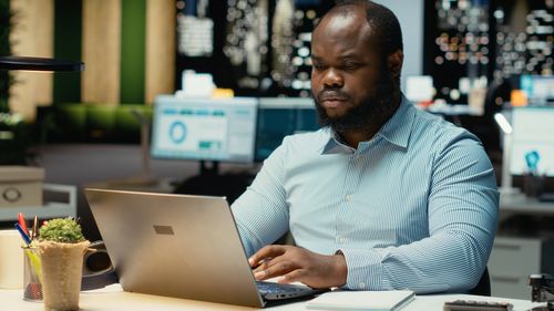 Portrait of man using laptop at table