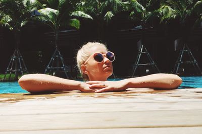 Young woman wearing sunglasses in swimming pool