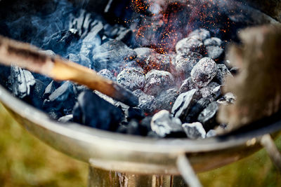 Closeup of glowing coal in metal grill on summer day in the garden