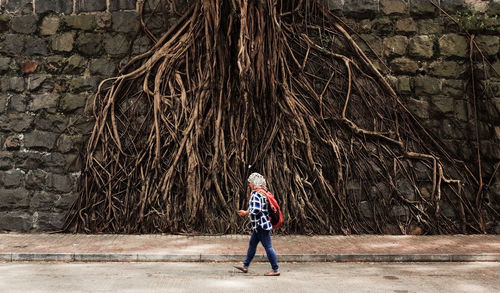 Full length of man standing against wall