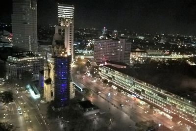 High angle view of illuminated street amidst buildings at night