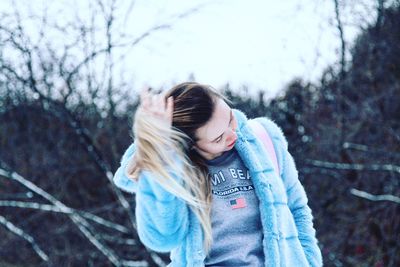 Girl standing on bare tree