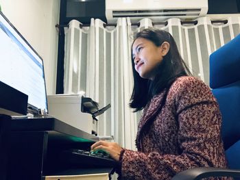 Low angle view of woman using computer in office