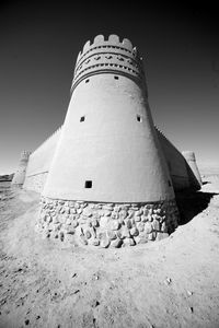 Low angle view of lighthouse amidst buildings against sky