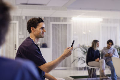 Man using smart phone in waiting room