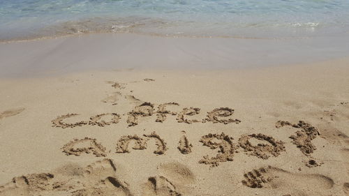 High angle view of text on sand at beach