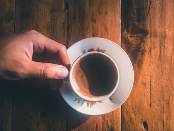 Person holding coffee cup on table