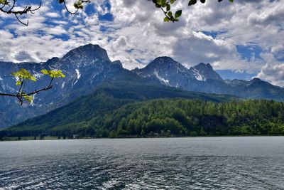 Scenic view of lake with mountains against cloudy sky