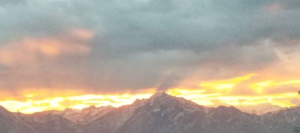 Scenic view of snowcapped mountains against sky during sunset