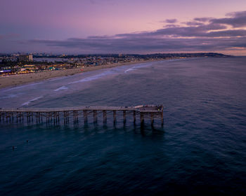 Aerial of crystal pier in pacific beach, san diego with beautiful turquoise water and purple sky