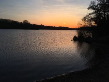 Scenic view of lake against sky at sunset