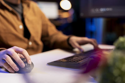 Midsection of man using laptop on table