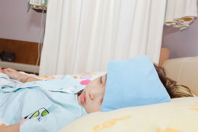 Close-up of boy sleeping on bed at home