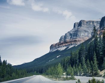 Road by mountains against sky