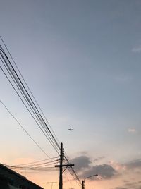 Low angle view of birds on electricity pylon against sky