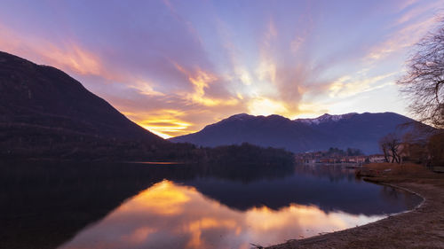 Scenic view of lake and mountains against sky during sunset