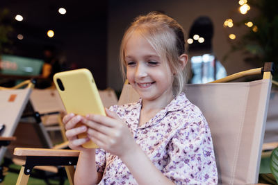 Portrait of young woman using mobile phone at home