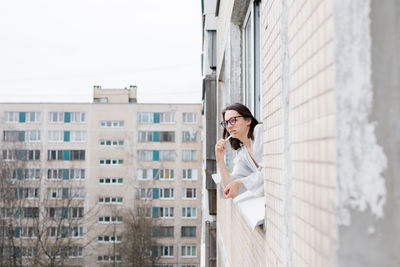 Woman wearing eyeglasses looking through window