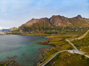 Scenic view of road by mountains against sky