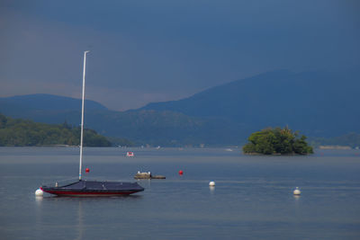 Sailboats in sea against sky