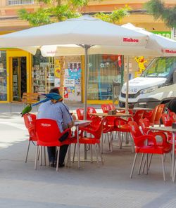 Chairs and tables at sidewalk cafe in city