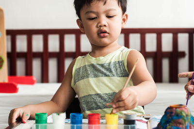 Cute boy looking away while sitting on table