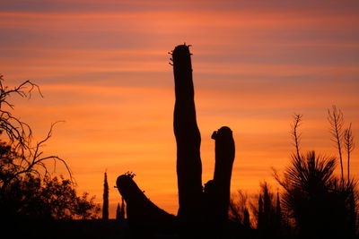 Low angle view of silhouette statue against sky at sunset