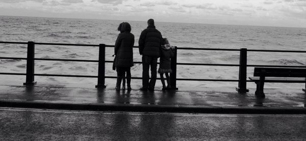 Man standing on pier at sea