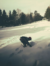 Man on snow covered field against sky