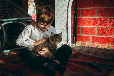 Portrait of cat sitting on bed at home