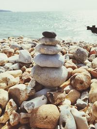 Stack of pebbles on beach against sky