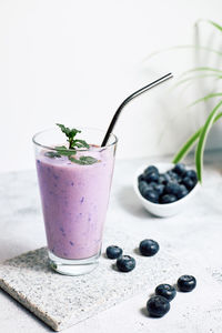 Blueberry smoothie in a glass on the table. ideal for vegetarian breakfast, diets and detox