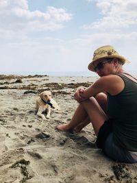 Side view of dog sitting on beach