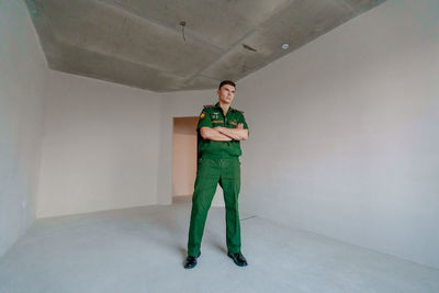 Portrait of young man standing against wall