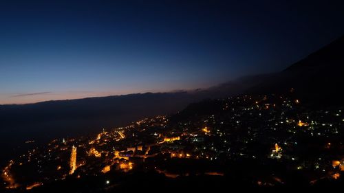 Aerial view of illuminated city against sky at night