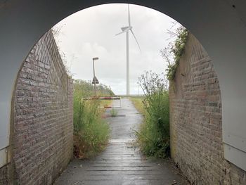 Empty footpath amidst buildings against sky
