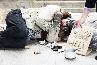 Beggar with message sleeping on road