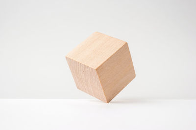 Close-up of wooden cube against white background