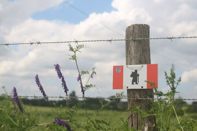 Information sign on field against sky