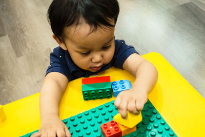 High angle view of baby boy playing with toys at home