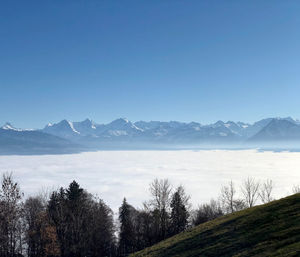 Scenic view of snowcapped mountains against clear blue sky